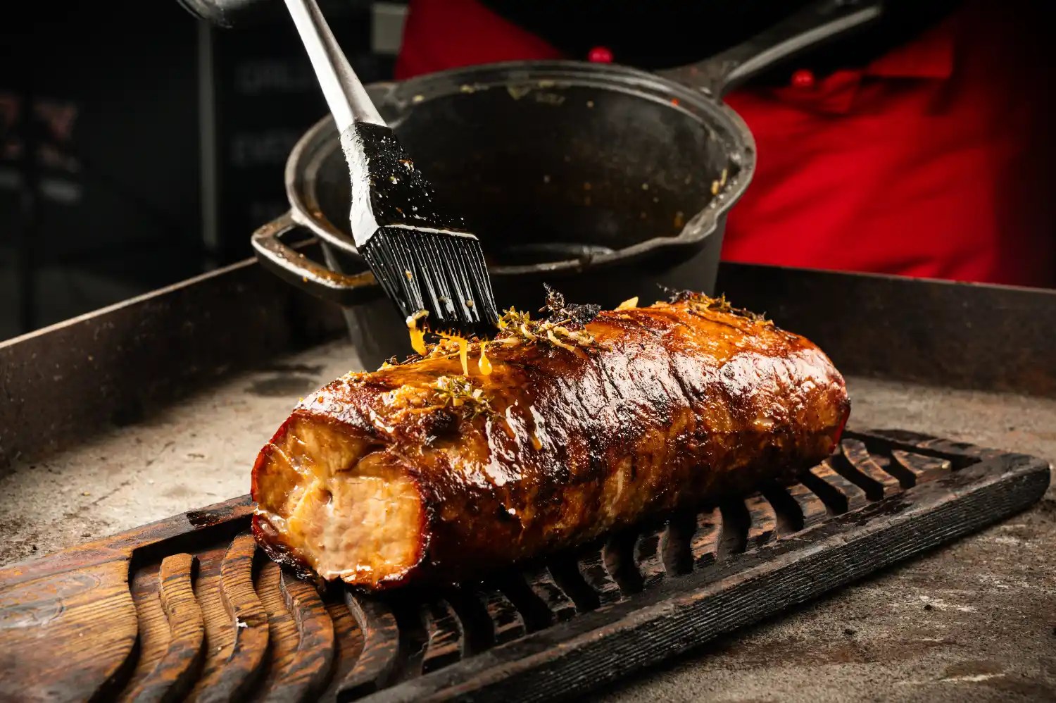 Bier-Basting-Sauce wird mit einem Pinsel auf gegrilltes Fleisch aufgetragen
