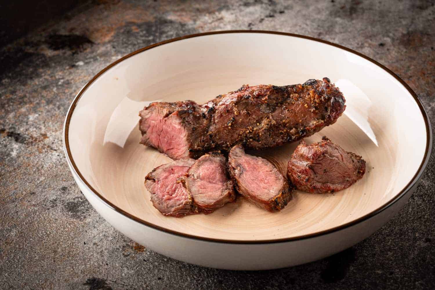 Aufgeschnittenes, gegrilltes Lagarto-Steak in einer hellen Schale.