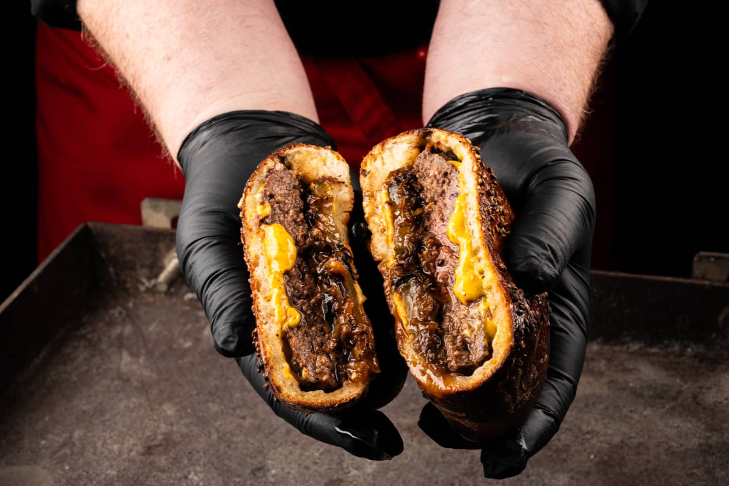 Aufgeschnittener gefüllter Burger im Pizzateig mit Käse, Fleisch und BBQ-Sauce